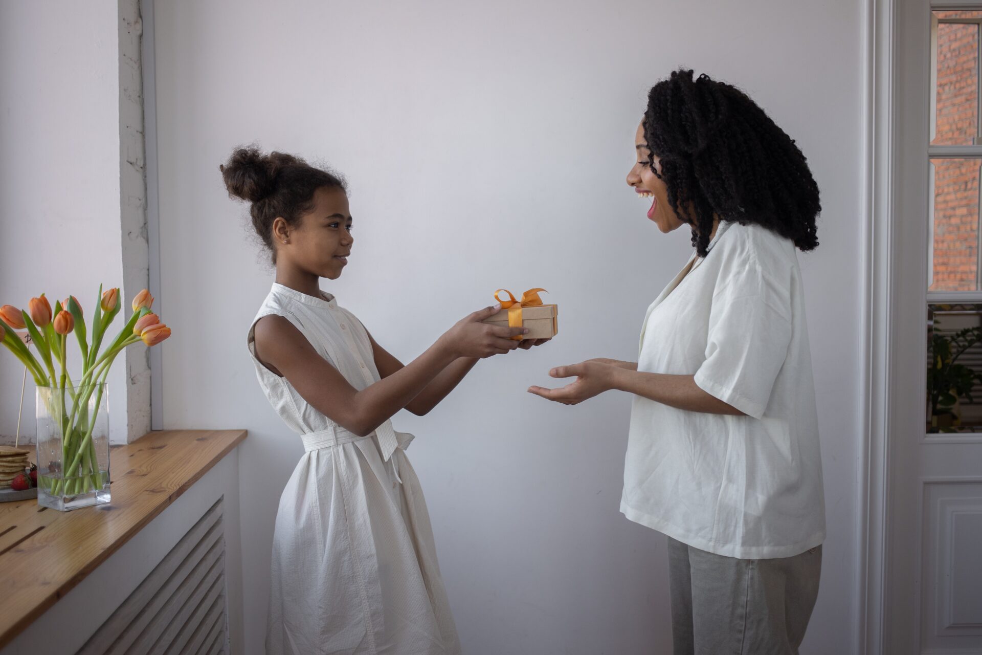 An African happy mom receiving gift from her teen daughter